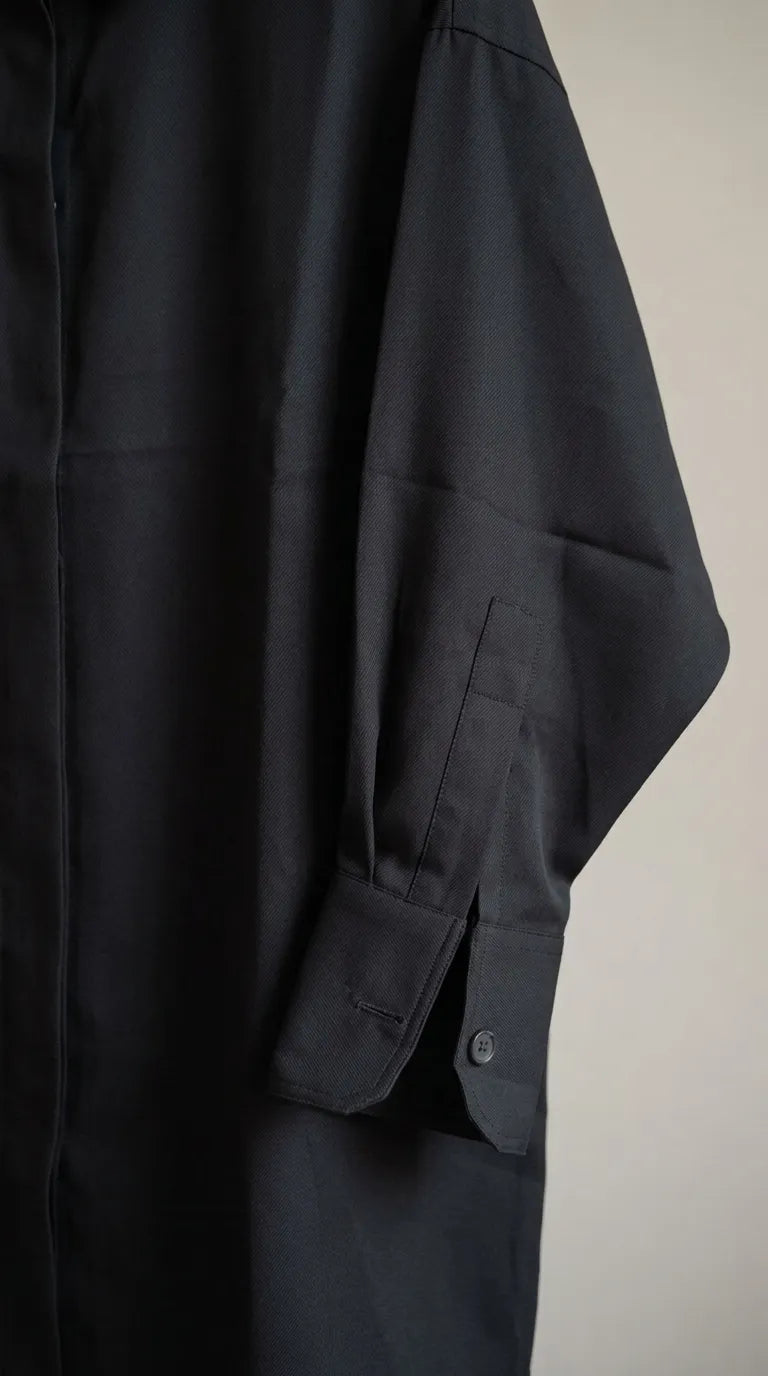 Close-up of the black shirt's button cuff and sleeve