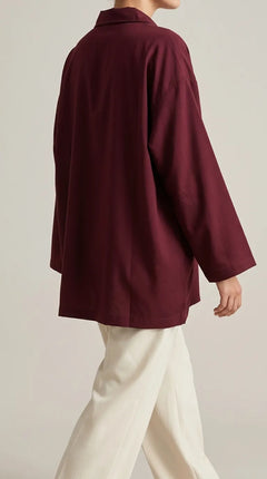 Maroon oversized shirt with dropped shoulders and wide sleeves, worn by a model, back three-quarter view