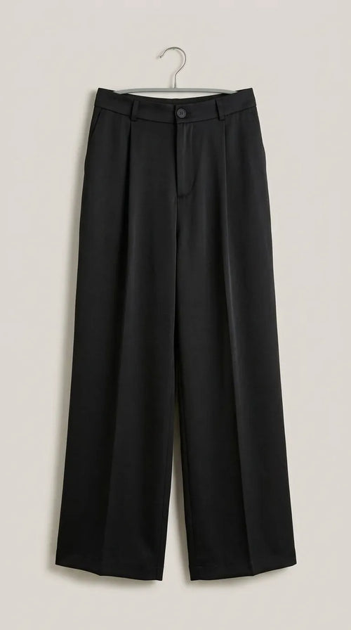 Black pleated wide-leg trousers hanging on a hanger, front view