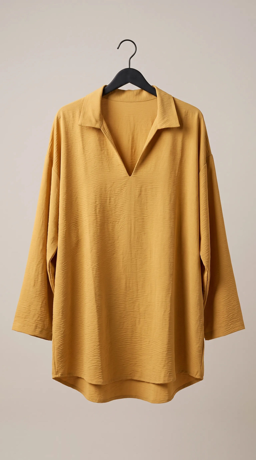 Mustard oversized V-neck pullover tunic hanging on a hanger, front view