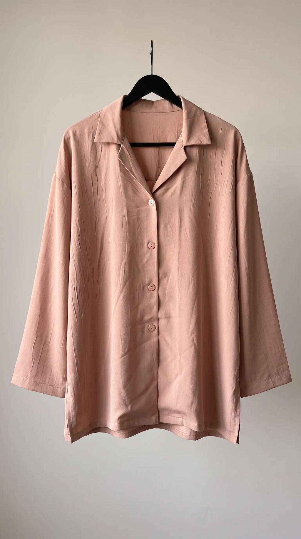 Dusty peach crinkled-crepe camp-collar shirt hanging on a hanger, front view