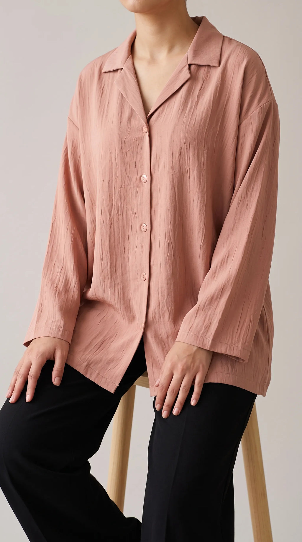Dusty peach oversized camp-collar shirt worn by a seated model, three-quarter front view