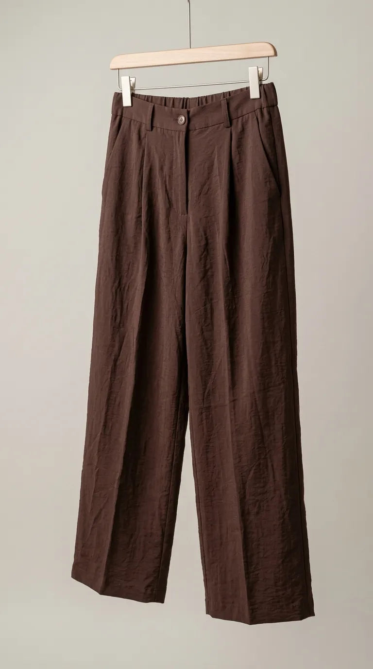 Chocolate brown pleated wide-leg trousers hanging on a hanger, front view